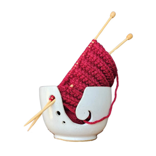 Ceramic yarn / wool bowl to hold your knitting or crochet project and keep it safe. A hand carved koru swirling shape on the side. Hand thrown in Christchurch and glazed with a silky white and slightly specked glaze. Seen here with deep red yarn and bamboo knitting needles.