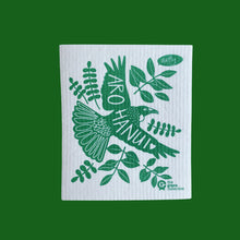 Arohanui Spruce dish cloth by The Green Collective. Natural and compostable dish cloth sits on a green background. The Swedish dishcloth pictured is the Arohanui design by local artist Cat from Natty, the design is a vibrant green Tui bird with wings outstretched and Arohanui which means with deep affection in te reo Māori written across the wingspan along with a love heart. Native New Zealand tree branches extend beneath the Tui in the same vibrant emerald green. 