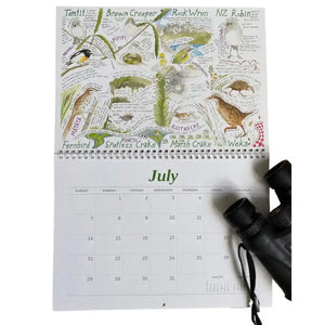 This 2024 Birding Calendar is the unofficial field guide to New Zealand birds. Seen here opened to the July month where you can see illustrations of Pūweto, Mātātā, Weka, Koitareke and many more Aotearoa NZ birds.The calendar is on a white background with a pair of binoculars resting on the calendar in the corner of the image.