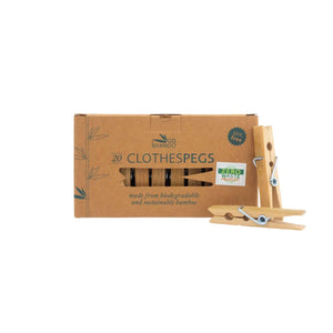 Go Bamboo organic clothes pegs, designed in New Zealand pictured in a cardboard box with 2 bamboo pegs alongside.