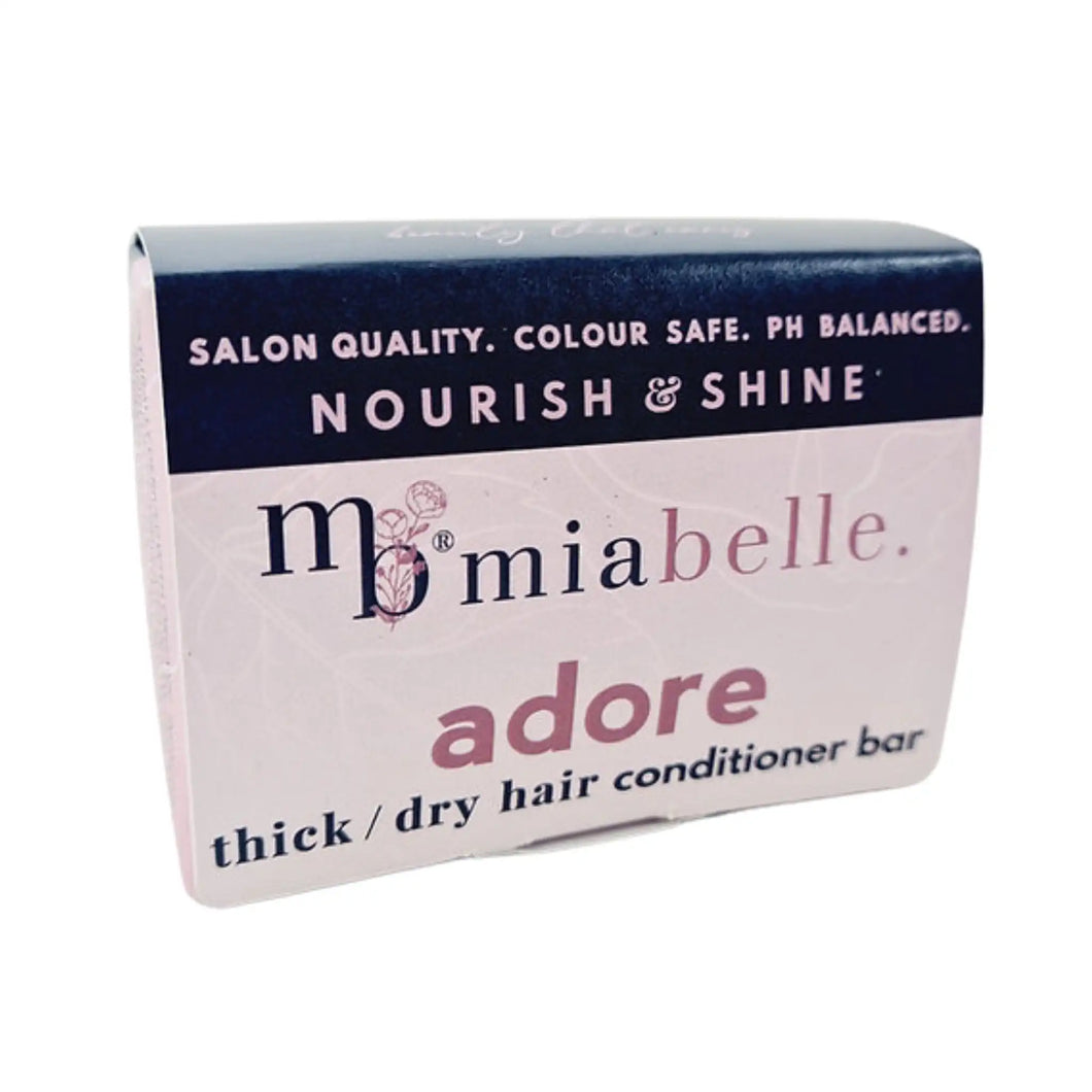 Mia Belle Adore thick / dry hair conditioner bar. Packaging pictured is a nice cool pink with a navy stripe across the top. The packaging reads: Salon quality, colour safe, pH balanced. Nourish and shine.
