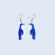Little Blue Penguin / Kororā earrings made by Remix Plastic from recycled plastic ice cream container lids. Here you can see the separate white and blue plastic pieces that come together to form the unique penguin outline.