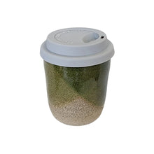 An espresso sized ceramic travel take-away coffee cup by Wellhandled Ceramics in a crossed dipped forest green glaze with speckled clay and a grey coloured silicone lid.