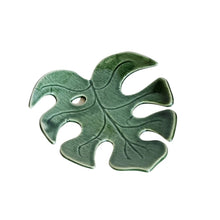 Decorative ceramic monstera leaf dish by Wellhandled Ceramics. Dark green with one leaf hole and distinctive leaf veins carved into the surface.