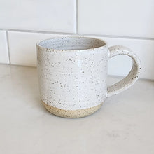 Ceramic coffee mug with handle handmade by Wellhandled Ceramics with a white speckled glaze.
