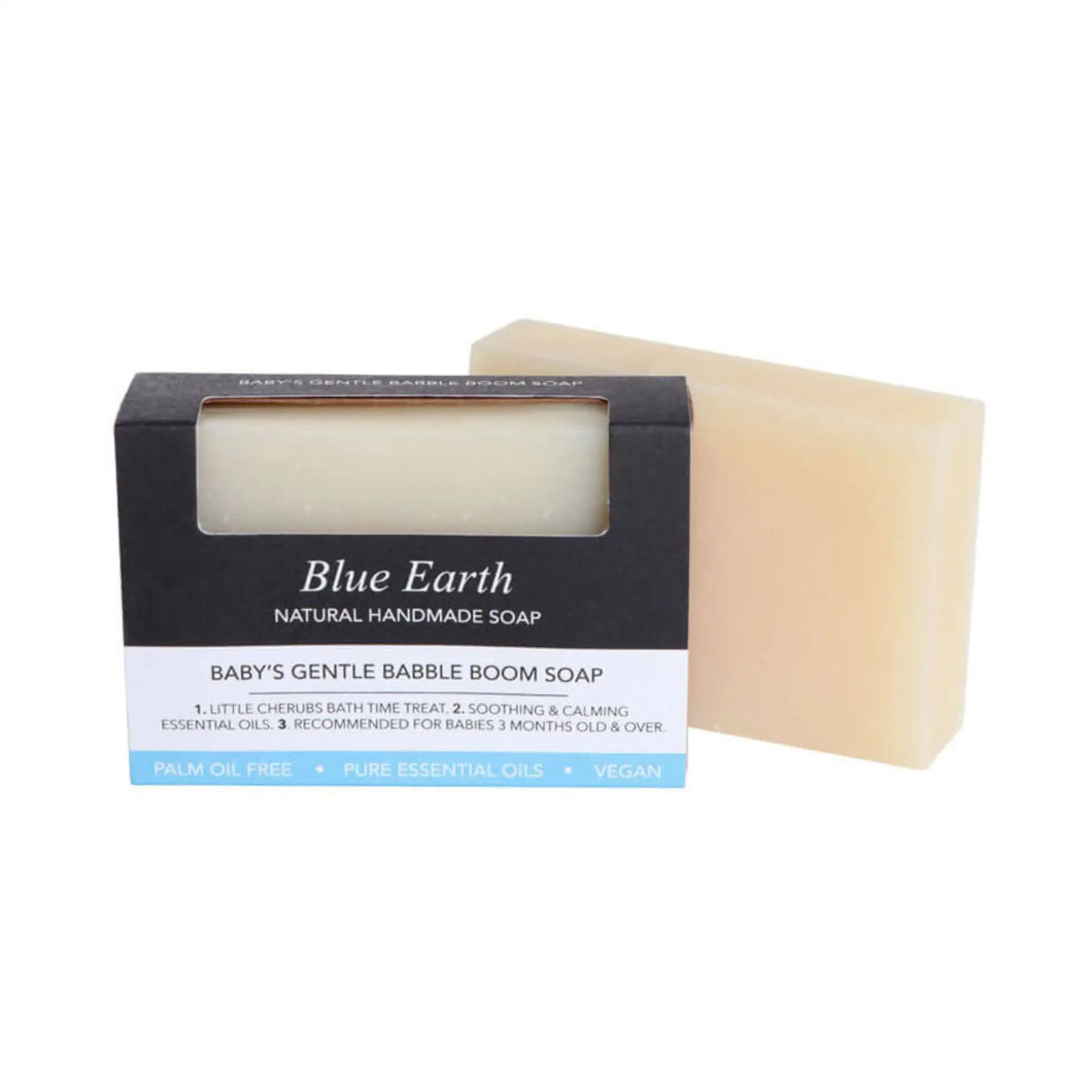 Blue Earth Baby's Gentle Babble Boom Soap bar, pictured with one bar packaged and one bar standing to the right and slightly behind the packaging. Packaging reads: Natural Handmade soap.