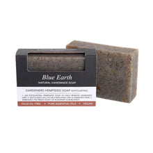 Blue Earth Gardeners Hempseed Exfoliating Soap bar, pictured with one bar packaged and one bar standing to the right and slightly behind. Label reads: Natural Handmade soap.