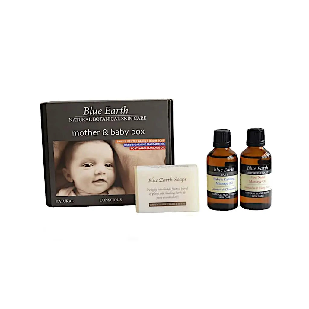 Mother and baby gift box by Blue Earth. Pictured here with the contents of the gift box standing next to the box itself. Post natal massage oil and baby's calming massage oil and standing beside the box next to baby's gentle bubble boom soap bar. Packaging reads: Natural, conscious, botanical skin care.
