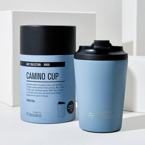 Made by Fressko Camino 12oz insulated and reusable stainless steel coffee cup in a lovely baby blue river colour with packaging in the background.