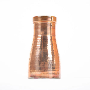 A beautiful avocado shaped copper water flask with a large lid that sits inside the top of the bottle which can be used as a cup to drink out of. 
