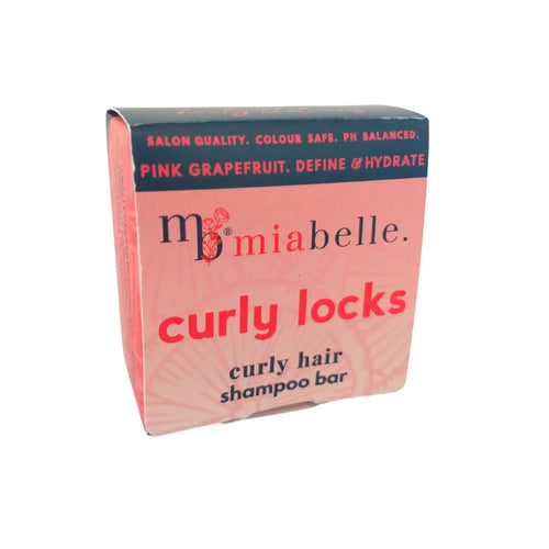 A shampoo bar for curly hair from Mia Belle. The shampoo bar is packaged in a pink box with a navy stripe at the top that reads: Salon Quality, Colour Safe, PH Balanced, Curly Locks shampoo bar for curly hair.