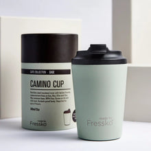 Made by Fressko reusable stainless steel 12oz Camino coffee cup in Sage green colour with packaging in the background.