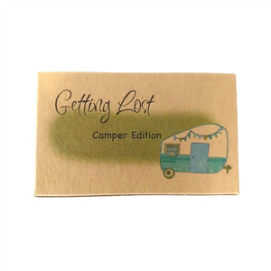 Camper edition of the Getting Lost Adventure game in a kraft cardboard box with a green cloud and a vintage blue and white camper van with blue and green bunting on the front.