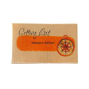 Walker's edition of the Getting Lost Adventure game in a kraft cardboard box with an orange cloud and a compass on the front.