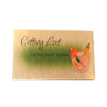 The Office Party edition of the Getting Lost Adventure game in a kraft cardboard box with green cloud and a cocktail glass with a striped straw and a pencil in it on the front.