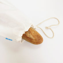 Closeup of large organic cotton loot bag containing baguette.