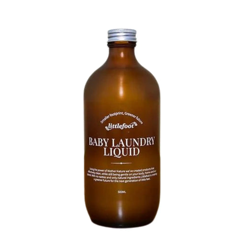 500ml amber glass bottle with aluminium screw-top lid containing Baby Laundry liquid. The clear label with white text reads: smaller footprint, greener future, Littlefoot logo, and Baby Laundry Liquid.