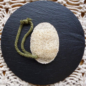 New Zealand grown Loofah body sponge with a soft cotton handle on a black background.