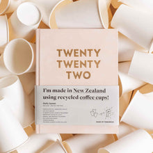 2022 Diary made in New Zealand from recycled coffee cups, sitting in a bed of these cups and with a paper sleeve advertising these facts.