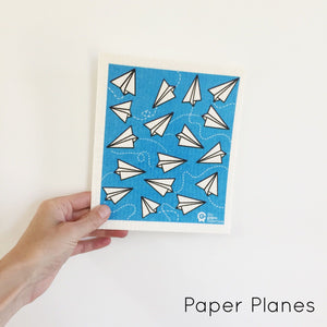 The Green Collective dish cloth with paper planes design.