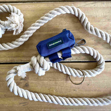 Poo pod is a Pet Waste Bag Dispenser, seen here attached to a dogs lead made out of rope.