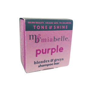 A purple shampoo bar for blonde or grey hair from Mia Belle. The shampoo bar is packaged in a purple box with a navy stripe across the top that reads: Salon Quality, Colour Safe, PH Balanced, Tone & Shine, blondes & greys shampoo bar.