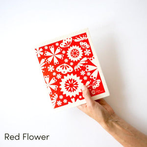 Natural dish cloth with white flowers on red background design.