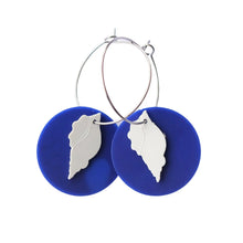 Eco friendly Beachcomber earrings made from recycled ice-cream container lids in Ōtautahi Christchurch by Remix Plastic. Hypoallergenic hoops which are silver in colour and a deep blue coloured disk with a white shell in front.