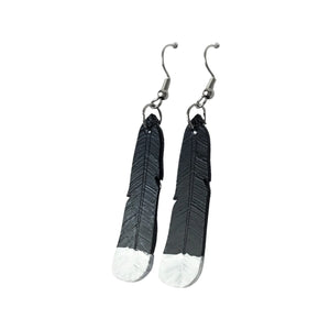 The new design of Remix Plastic's Huia feather earrings, made from recycled 3D printer waste. Black feathers with painted white tips.