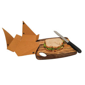 SammyBags sandwich wrap in natural. Pictured laying open and flat next to a sandwich and bread knife sitting on a bread board.