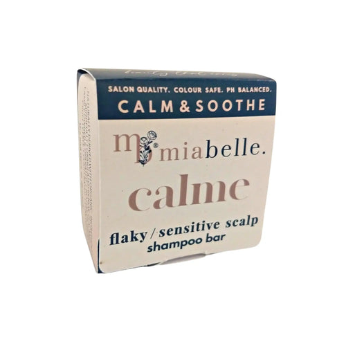 Calme by Mia Belle - A sensitive shampoo bar designed to calm and soothe dry, itchy, flaky or sensitive scalps. The shampoo bar box pictured is a creamy colour with a navy stipe across the top which reads Salon Quality, colour safe, ph balanced. Calm & Soothe. 