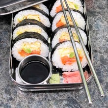 Stainless-steel lunchbox by Bento Ninja which is perfect for sushi. Pictured with stainless-steel chopsticks and full of delicious sushi, soy sauce, wasabi and pickled ginger. The perfect plastic-free lunch!