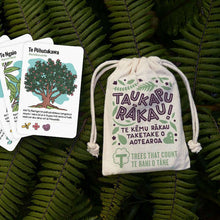 Tree Snap New Zealand's Native Tree Game, now available in te reo Māori - Taukapu Rākau! Te kēmu rākau taketake o Aotearoa, beautifully illustrated cards in a cotton drawstring bag on a bed of dark green fern leaves and featuring Te Pōhutukawa and Te Ngaio cards.
