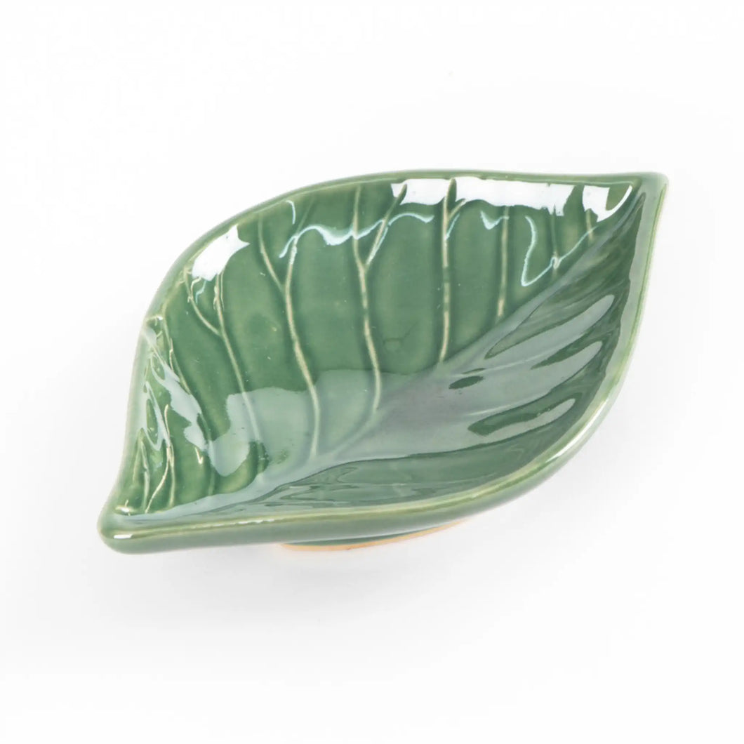 Green ceramic dish in the shape of a leaf.