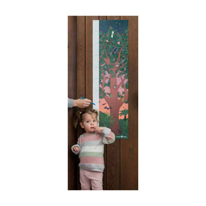 A growth chart from Tress That Count / Te Rahi O Tāne in action with a small person in the foreground wearing a pastel pink outfit and a hand marking the small persons height on the beautifully illustrated growth chart.