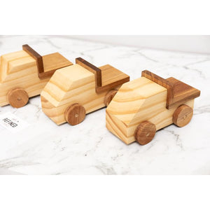 A row of wooden toy trucks handmade with care from reclaimed Rimu and sustainably sourced Pine timber.